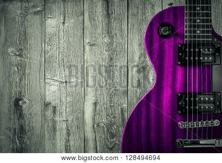 Part of the pink electric guitar on wooden background. A place for writing of the text