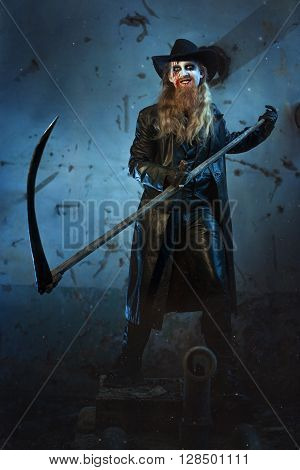 Man with a wicked smile holding a scythe in his hand to kill.