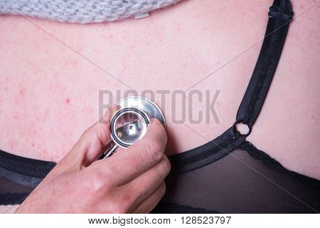 female doctor is listening to lunge of female patient