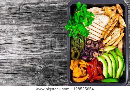 Delicious Chicken Fajita Platter with Avocado Bell Pepper Grilled Pita Red Onion and Cilantro blank space left top view