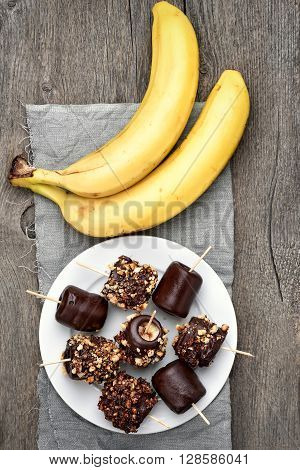 Frozen banana and fresh fruits on wooden background top view