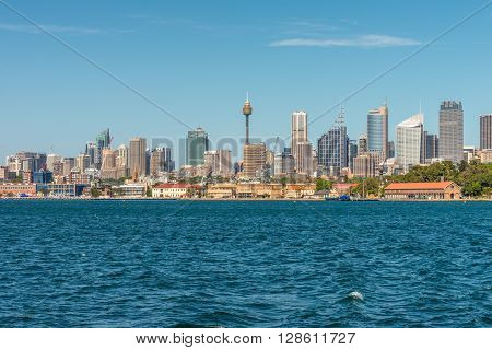 Sydney Australia - November 9 2014: Water front panorama of Sydney Central Business District office buildings showing centrepoint tower Sydney New South Wales Australia. The Garden Island dockyard in the foreground.