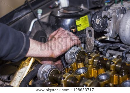 Hands Repairing A Car Engine With A Wrench