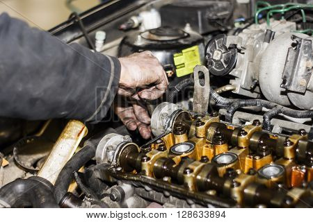 Hands Repairing A Car Engine With A Wrench