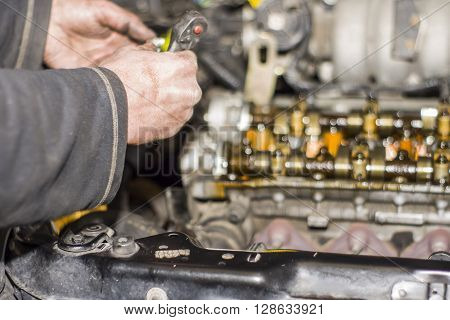 Hands Repairing A Car Engine With A Wrench