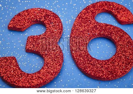 Number thirtysix red color over a blue background. Anniversary. Horizontal