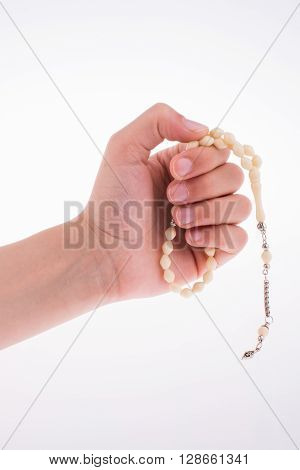 Hand holding a tespih on a white background
