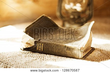 ancient and torn bible illuminated by a sunbeam