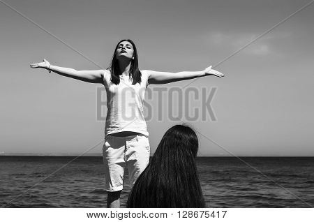 Sisters At Beach Hugging Each Other. Portrait Of Beautiful Young