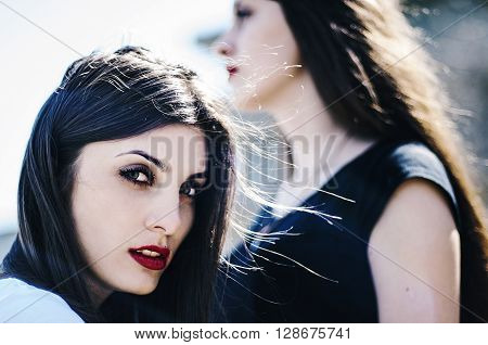 Sisters At Beach Hugging Each Other. Portrait Of Beautiful Young Girls, Sisters, Against The Backdro
