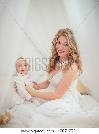 Beautiful woman with young daughter in white dress