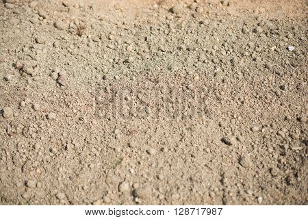 Brown lumpy soil in a shady light as a background