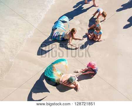 COOGEE,WA,AUSTRALIA-APRIL 3,2016: Family meet and greet with live interactive mermaids entertainers in costume at the Coogee Beach Festival in Coogee, Western Australia.