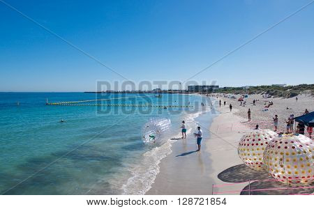 COOGEE,WA,AUSTRALIA-APRIL 3,2016: Coogee Beach Festival with families and floating inflatable water balls in the Indian Ocean waters of Coogee, Western Australia.