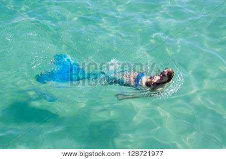 COOGEE,WA,AUSTRALIA-APRIL 3,2016: Live mermaids entertainer floating in the turquoise Indian Ocean at the Coogee Beach Festival in Coogee, Western Australia.