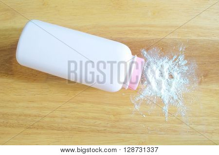 Talcum powder with container on wooden background