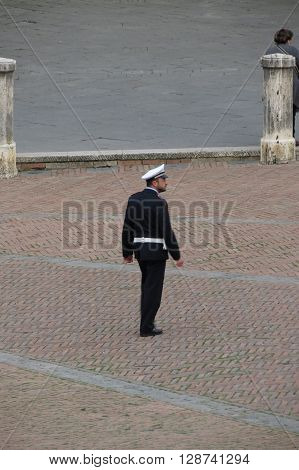 SIENA ITALY - CIRCA APRIL 2016: Italian Polizia Municipale (i.e. Town Police) officer patroling the main square aka il Campo