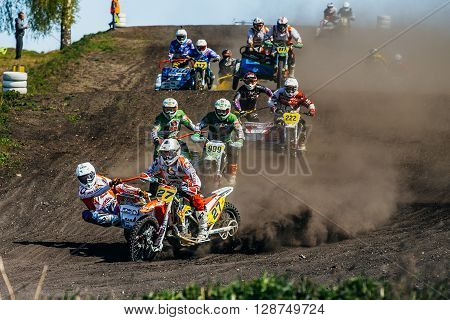 Miasskoe Russia - May 02 2016: group of motorcyclists with sidecars riding along a dusty track during Cup of Urals motocross