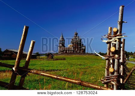 Kizhi Pogost on Kizhi Island, Karelia, Russia. Church of Transfiguration, Church of Intercession, and Bell-tower (UNESCO Cultural Heritage Site) seen from behind the Wooden Fence