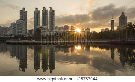 Beauty landscape sunrise over modern building in the park at Bangkok Thailand (Benchakitti Park)