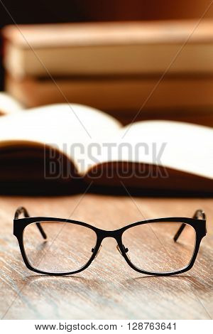 Glasses, book and cup of tea on a wooden table