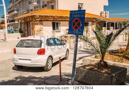 The car is parked under a sign prohibiting parking. In Greece resorts nobody follows the rules of the road.