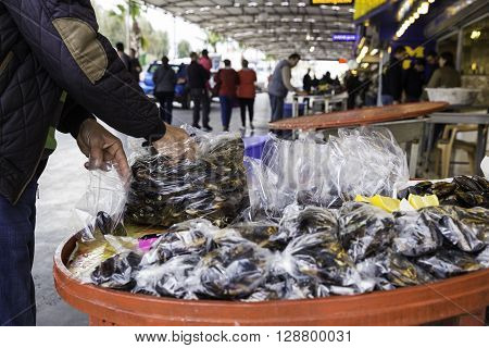 Turkish style stuffed mussels called midye dolma on the bench for sale in a local market