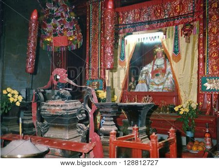 MACAU - CIRCA 1987: An idol sits on an altar inside the A-Ma Temple, built in 1488, and dedicated to Matsu, the goddess of seafarers and fishermen.