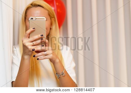 Attractive and seductive girl taking selfie on isolated background.