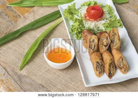 Egg roll vietnamese cuisine in thai style with sweet suace on wooden table