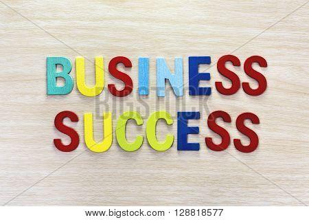 Business success in multicolor on wooden table Letter spelling business success. Business success concept