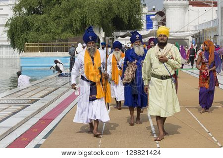 AMRITSAR INDIA - SEPTEMBER 26 2014: Unidentified Sikhs and indian people visiting the Golden Temple in Amritsar Punjab India. Sikh pilgrims travel from all over India to pray at this holy site