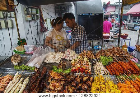 KO PHA NGAN, THAILAND - FEBRUARY 7, 2016: Unidentified sellers of thai food. Street food is a quintessential part of the Thai experience.