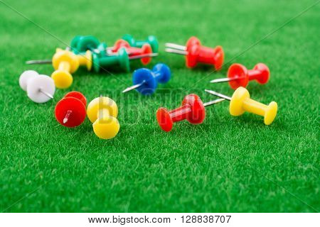 Some colorful pins on a green grass