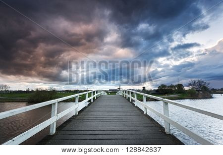 Wooden Bridge On The Background Of Dramatic Cloudy Sky
