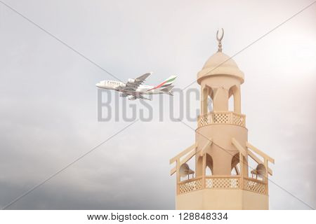 DUBAI, United Arab Emirates - DECEMBER 22, 2016: An Emirates aircraft is taking off from DXB airport near mosque