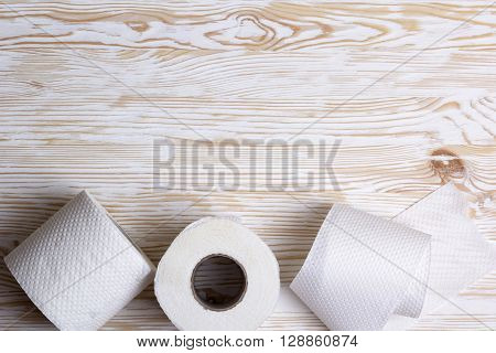 Rolls of toilet paper on wooden board