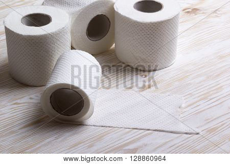 Rolls of toilet paper on wooden board