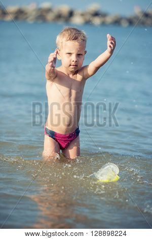Little boy with snorkel by the sea. Cute little kid wearing mask and flippers for diving at sand tropical beach. Ocean coast.