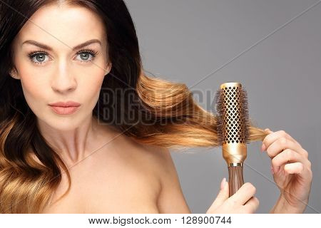 Laying, modeling hair on a round brush.