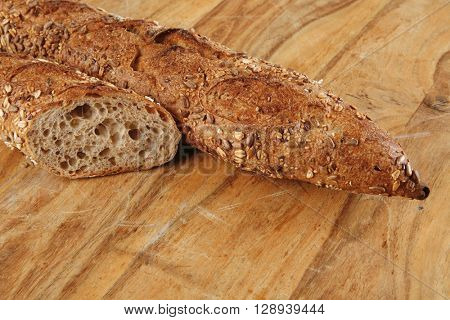 long french fresh rye baguette on light wooden table