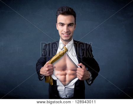 Businessman tearing off his shirt and showing mucular body concept on background