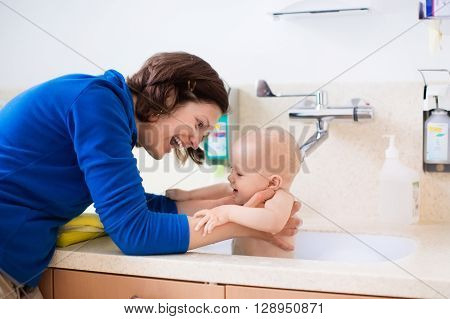 Mother washing her baby in a hospital room. Mom bathing little boy during clinic stay at children station. Health care and for young kids. Parent and child stay in room. Infant recovery after sickness