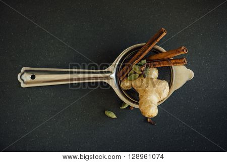 Authentic indian tea spice mix arrange in a typical tea strainer. Indian masala tea ingredients.