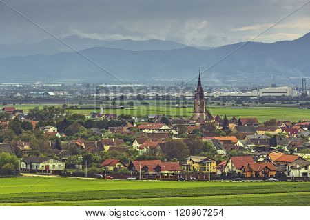 Rural scenery with the steeple of the fortified German church in Sanpetru village a commune located at 5 km north of Brasov city in Transylvania region Romania
