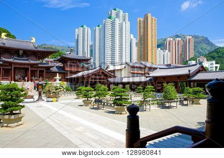 Hong Kong China - September 26 2007: People in the Chi Lin antique monastry and in the background the towers of the new Kowloon quarter