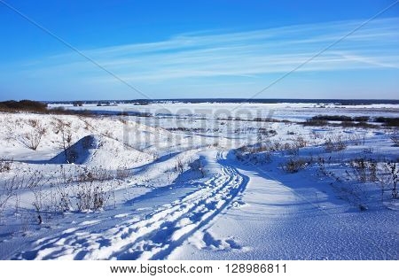 Country Road Covered With Snow In The Winter Field