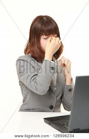 portrait of young Japanese businesswoman suffers from Asthenopia on white background