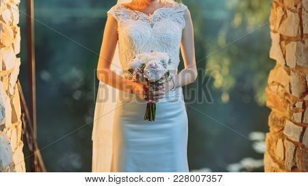 Beautiful Bouquet Of Different Colors In The Hands Of The Bride In A White Dress