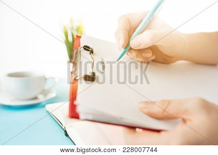 Male Hands Holding Pen, Writing. Side View On Man On Trendy Color Blue Desk. Man And Stilish Workpla